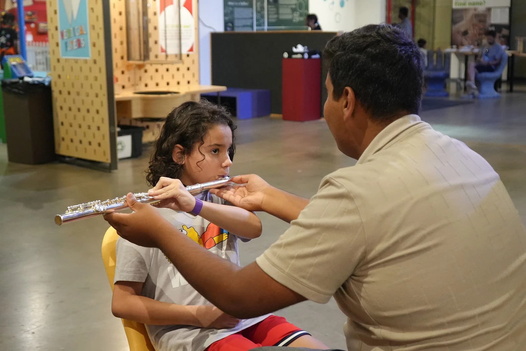 Student learning flute with tutor guidance